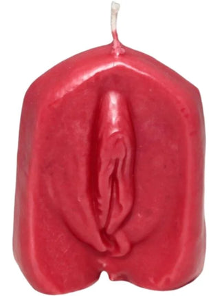 Eine vibrierend rote glänzende wachskerze mit detailliert gestalteter vulva als motiv auf der oberfläche