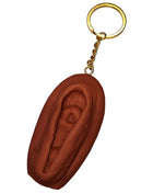 Brauner vagina-schlüsselanhänger diablo picante mit goldfarbenem metallring und kette in dunkler tonfarbe