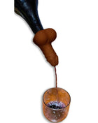 Braune silikon weinkaraffe in penisform mit dunklem flaschenhals gießt roten wein ins glas diablo picante