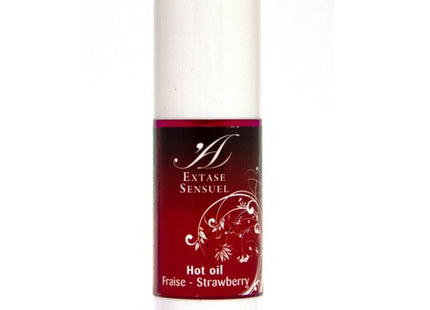 Ein schlanker weißer zylinderflasche mit rotem etikett und silbernen blumendesigns extase sensuel hot oil fraise erdbeeröl 30 ml