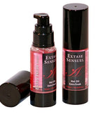 Zwei schwarze zylindrische flaschen extase sensuel massageöl mit extra frischem erdbeer effekt und pinken etiketten