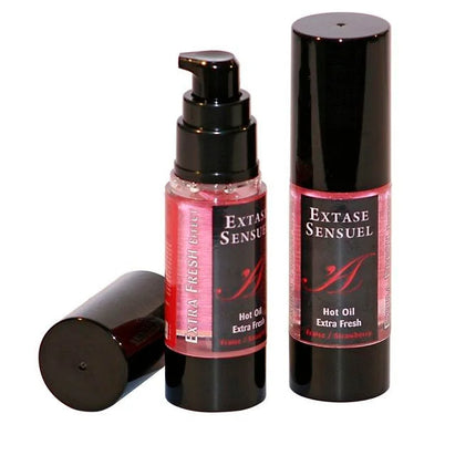 Zwei schwarze zylindrische flaschen extase sensuel massageöl mit extra frischem erdbeer effekt und pinken etiketten