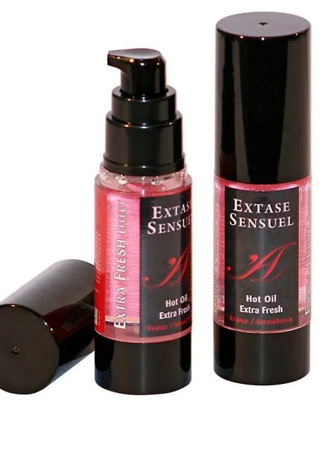 Zwei schwarze zylindrische flaschen extase sensuel massageöl mit extra frischem erdbeer effekt und pinken etiketten