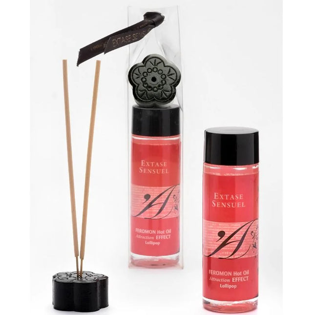 Schwarze floral geformte diffuser basis mit holzstäbchen und zwei rosa etikettierten extase sensuel massageolflaschen 100 ml