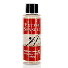Eine klare flasche mit schwarzem deckel enthält rote etikettierte extase sensuel massageöl mit wärmeeffekt und pirulet pheromonen