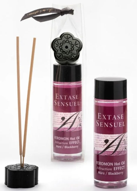 Schwarzer diffuser in floraldesign mit holzstäbchen und passendem sockel verpackt mit schwarzer schleife extase sensual massageöl mit wärmeeffekt und brombeerpheromonen 100 ml