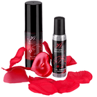 Zwei schwarze flaschen extase sensuel intime lubrikant hot oil und lubrikant erdbeere umgeben von roten rosenblättern