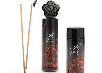Schwarzer blumenförmiger reed diffuser mit passendem deckel und zwei bernsteinfarbenen extase sensual schokoladen und orangen ölbottles