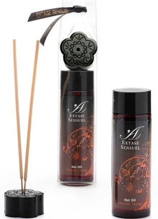 Schwarzer blumenförmiger reed diffuser mit passendem deckel und zwei bernsteinfarbenen extase sensual schokoladen und orangen ölbottles