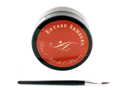 Ein eleganter schwarzer zylinderbehälter mit rotem deckel und goldener monogrammierung für extase sensual schokoladenkörperlack 50 ml