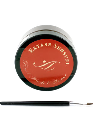 Ein eleganter schwarzer zylinderbehälter mit rotem deckel und goldener monogrammierung für extase sensual schokoladenkörperlack 50 ml