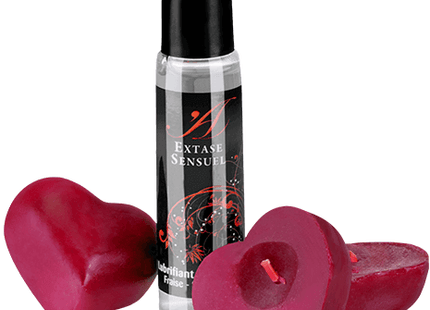 Ein klarer glas-rollerball mit schwarzem deckel und label extase sensuel neben zwei herzförmigen roten kerzen