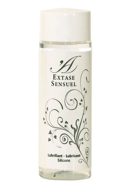 Eine klare Glasflasche mit weißem Verschluss und schwarzem Blumenmuster, extase sensual silikon gleitmittel 100 ml
