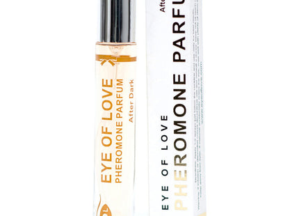 A sleek transparent glass rollerball bottle with silver cap and gold eye of love pheromon parfum after dark label beside white box