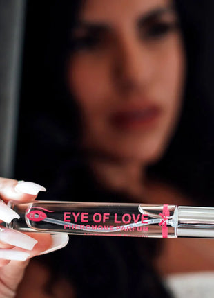 Ein eleganter transparenter glas-rollerball-flakon mit silberner kappe und pinker markierung für eye of love pheromon parfum