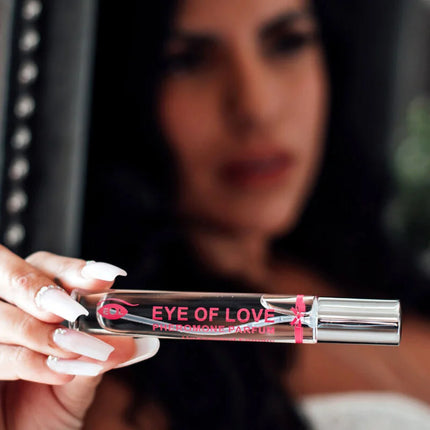 Ein eleganter transparenter glas-rollerball-flakon mit silberner kappe und pinker markierung für eye of love pheromon parfum