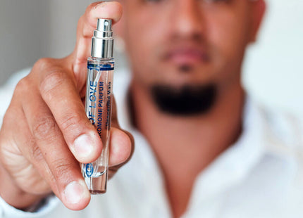Ein eleganter transparenter glas-sprayflakon mit silberner kappe und blauem dior homme parfum etikett für männer