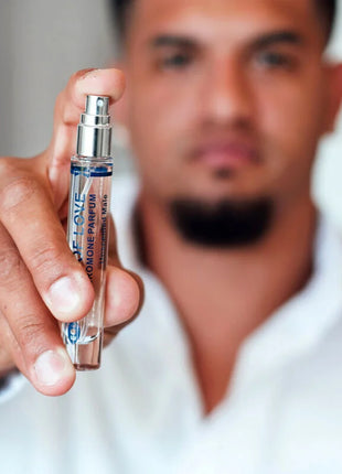 Ein eleganter transparenter glas-sprayflakon mit silberner kappe und blauem dior homme parfum etikett für männer