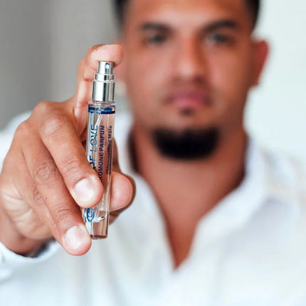Ein eleganter transparenter glas-sprayflakon mit silberner kappe und blauem dior homme parfum etikett für männer
