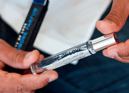 Ein schlanker transparenter glas-roller mit silberverschluss und blauer etikette eye of love pheromonparfum für männer