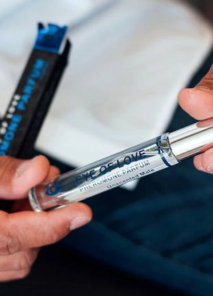 Ein schlanker transparenter glas-roller mit silberverschluss und blauer etikette eye of love pheromonparfum für männer