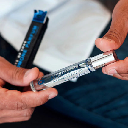 Ein schlanker transparenter glas-roller mit silberverschluss und blauer etikette eye of love pheromonparfum für männer