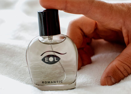 Klare glasparfümflasche mit schwarzem deckel und augenförmigem logo eol über dem wort romantic für den parfum deluxe 50 ml