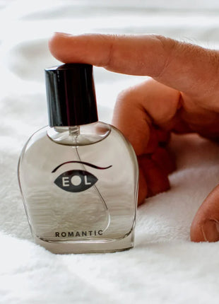 Klare glasparfümflasche mit schwarzem deckel und augenförmigem logo eol über dem wort romantic für den parfum deluxe 50 ml