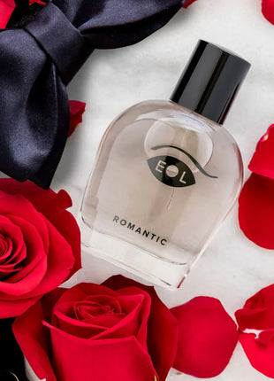 Klarer glasparfümflakon mit schwarzem verschluss und minimalistischem augenlogo etikettiert romantic von eol