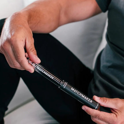 Schwarze zylindrische matchmaker vakuumpumpe mit transparenter sektion und silbernen metallakzenten für eye of love parfum