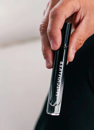Schwarze und klare glasflasche mit matchmaker beschriftung gehalten in hand pheromon-parfüm eye of love 10 ml