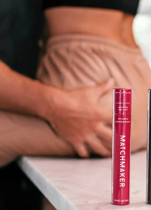 Zwei zylindrische eye of love matchmaker mascara tubes in rot und schwarz mit weißer schrift auf matter oberfläche