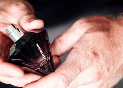 Ein dunkel gefacettetes glas-parfümfläschchen eye of love matchmaker black diamond pheromon-parfüm mit silbernen spraykopf 30 ml