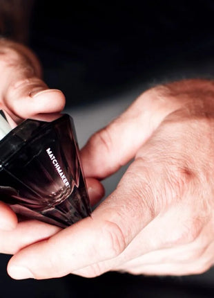 Ein dunkel gefacettetes glas-parfümfläschchen eye of love matchmaker black diamond pheromon-parfüm mit silbernen spraykopf 30 ml