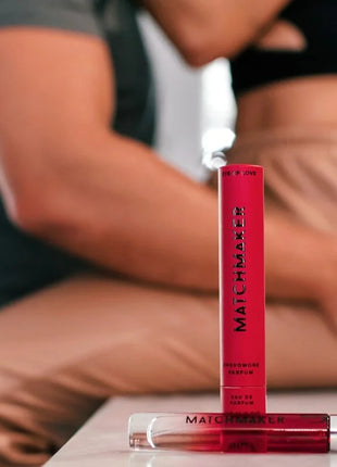 Ein leuchtend roter zylindrischer parfümflakon eye of love matchmaker mit klarem glaskappen und schwarzer schrift