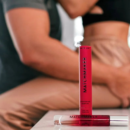 Ein leuchtend roter zylindrischer parfümflakon eye of love matchmaker mit klarem glaskappen und schwarzer schrift