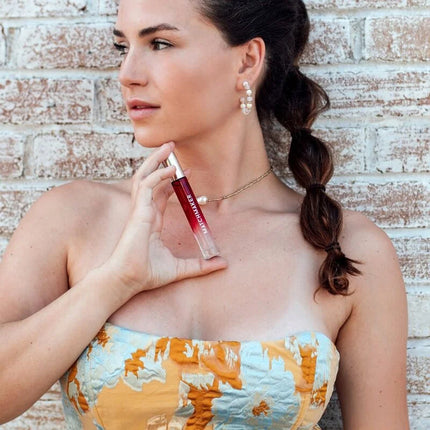 Ein glänzendes, durchsichtiges rotes lipgloss in einem schlanken röhrchen mit silberkappe von manchurer im 10 ml eye of love matchmaker red diamond parfum set