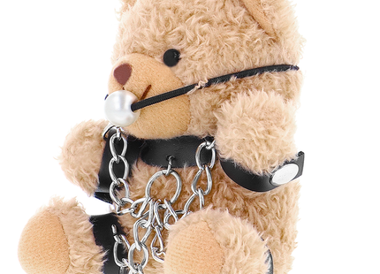 Ein beige plüschteddy mit schwarzen lederriemen silberketten und perlenknebel im fetisch submissive foZZie teddyBär bdsm modell 3