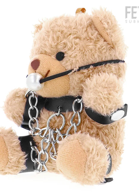 Ein beige plüschteddy mit schwarzen lederriemen silberketten und perlenknebel im fetisch submissive foZZie teddyBär bdsm modell 3