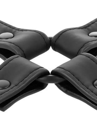Schwarze handschellenverbindung aus veganem leder mit nähte und metallknopfbefestigungen