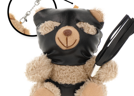 Black ledermaske bedeckter teddy mit hellbraunem fell und lächelndem gesicht hält schwarzen peitsche für bdsm spielzeug