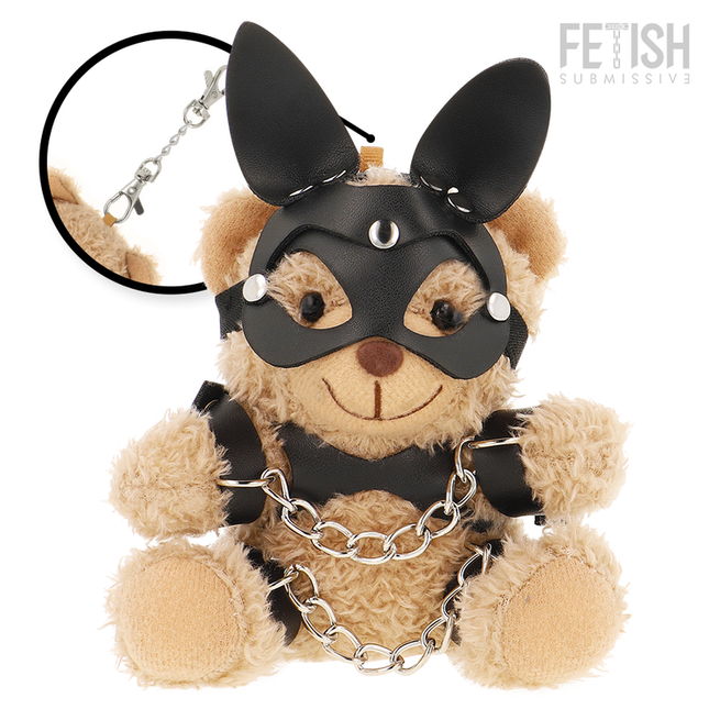 Ein tanfarbener plüsch-teddybär fetisch submissive mit schwarzer ledermaske, nieten, ohrstücken, schwarzem harness und silberner kette