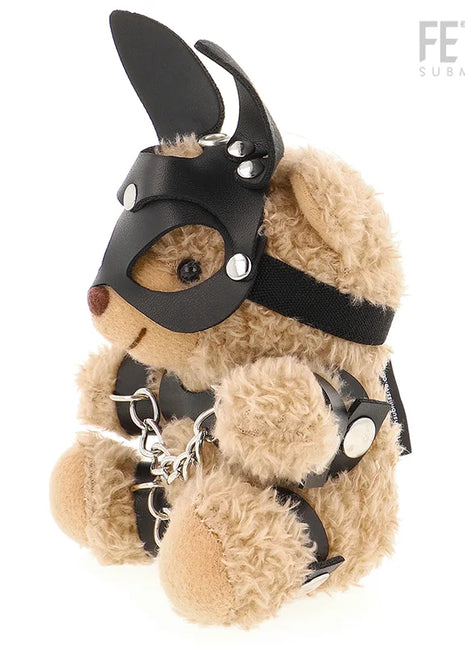 Ein plüschiger tanfarbener teddy bär im fetisch submissive stil mit schwarzer ledermaske, silbernen nieten und kettenharness