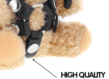 Ein tanfarbener plüsch teddy mit schwarzen veganlederriemen und silbernem metallbeschlag für bdsm nutzen