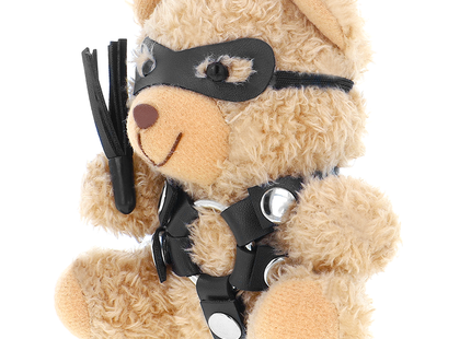 Ein beiger plüsch-teddybär mit schwarzer ledermaske und harness hält einen schwarzen lederflogger, fetish submissive modell 2