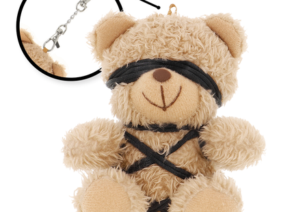 Ein beiger plüsch teddy mit schwarzen stoffriemen am gesicht und körper im fetish submissive winnie teddybär bdsm modell 6