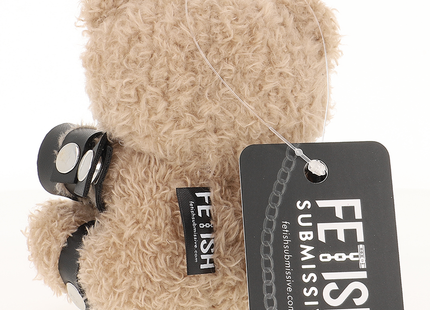 Ein beiger plüschteddy yodi teddy bär mit schwarzen lederähnlichen manschetten und silbernen metallakzenten von fetish submissive