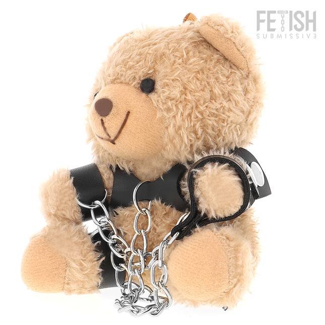 Ein plüschiger tanfarbener yohgi teddybär mit schwarzem ledergeschirr und silbernen kettensperren im bdsm stil