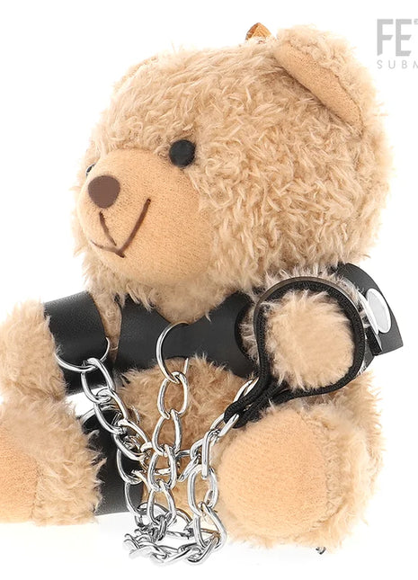 Ein plüschiger tanfarbener yohgi teddybär mit schwarzem ledergeschirr und silbernen kettensperren im bdsm stil