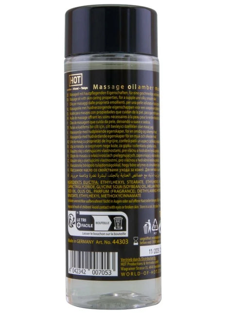 Klar glasflasche mit schwarzem verschluss und etikett mit transparentem massageöl amber und moschus 100 ml